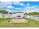 Outdoor kitchen and patio area with a grill, shade, and beautifully landscaped yard at 14417 Barley Field Dr, Wimauma, FL 33598