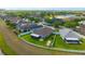 Aerial view of a well maintained backyard with a patio, landscaping, a privacy fence and blue skies at 14417 Barley Field Dr, Wimauma, FL 33598