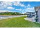 Large backyard featuring green grass, white fencing, and a lake view at 14417 Barley Field Dr, Wimauma, FL 33598