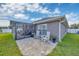 Comfortable backyard patio with rocking chairs and a screened-in lanai, perfect for enjoying outdoor relaxation and gatherings at 14417 Barley Field Dr, Wimauma, FL 33598