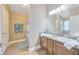 Bright bathroom featuring double sinks with granite countertops, wood cabinets, and bath/shower combo at 14417 Barley Field Dr, Wimauma, FL 33598
