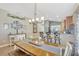Open dining room with modern chandelier and decorative wall art, seamlessly connecting to the kitchen at 14417 Barley Field Dr, Wimauma, FL 33598