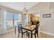 Dining area with a dark wood table and chairs, view of the kitchen, and natural light at 14417 Barley Field Dr, Wimauma, FL 33598