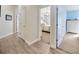 Hallway featuring light wood flooring with views into rooms with carpet and access to rooms with doors at 14417 Barley Field Dr, Wimauma, FL 33598