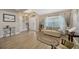Bright living room with light wood floors, neutral walls, and comfortable seating arrangement at 14417 Barley Field Dr, Wimauma, FL 33598
