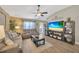 Comfortable living room featuring wood floors, ceiling fan, and seamless flow to the outdoor space at 14417 Barley Field Dr, Wimauma, FL 33598