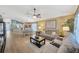 Inviting living room flowing to dining area, featuring wood floors, ceiling fan, and comfortable seating at 14417 Barley Field Dr, Wimauma, FL 33598