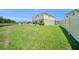 Large backyard with outdoor patio featuring a hammock, fire pit, and a spacious lawn for outdoor enjoyment at 18161 Hunters Meadow Walk, Land O Lakes, FL 34638
