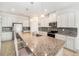 A kitchen featuring a large granite island, stainless steel appliances, and white cabinetry at 18161 Hunters Meadow Walk, Land O Lakes, FL 34638