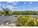 Scenic backyard view showing an enclosed pool area, lush landscaping, and a serene lake at 20347 Chestnut Grove Dr, Tampa, FL 33647