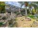 Lush backyard featuring a screened-in patio, a fire pit, and vibrant landscaping at 20347 Chestnut Grove Dr, Tampa, FL 33647