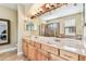 Bathroom featuring double sinks, large mirrors, wooden cabinets and a walk in shower at 20347 Chestnut Grove Dr, Tampa, FL 33647