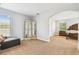 Spacious carpeted bedroom with seating area and arched entryways to other rooms at 20347 Chestnut Grove Dr, Tampa, FL 33647