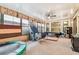 Spacious bonus room with an air hockey table, seating, large windows, and a ceiling fan at 20347 Chestnut Grove Dr, Tampa, FL 33647