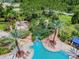 Aerial view of a stunning community pool with lush landscaping, slides, and various seating areas for relaxation and recreation at 20347 Chestnut Grove Dr, Tampa, FL 33647
