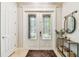 Elegant white double front door with decorative glass panels and a stylish entryway mirror at 20347 Chestnut Grove Dr, Tampa, FL 33647