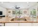 Kitchen island with stainless steel sink and granite countertops overlooking a living area with a large window at 20347 Chestnut Grove Dr, Tampa, FL 33647