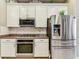 Kitchen featuring stainless steel appliances, granite countertops, and white cabinetry for a modern design at 20347 Chestnut Grove Dr, Tampa, FL 33647