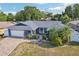 Beautifully landscaped home with mature trees, a brick driveway, and well-maintained lawn at 206 Timberview Dr, Safety Harbor, FL 34695