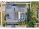 An aerial view showcases a house with solar panels and a screened-in pool surrounded by palm trees at 206 Timberview Dr, Safety Harbor, FL 34695