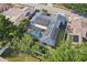 Aerial view of a house with solar panels and a screened-in pool surrounded by lush greenery at 206 Timberview Dr, Safety Harbor, FL 34695