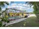 This image shows a beautiful backyard with a pool, artificial turf, and a screened-in lanai at 206 Timberview Dr, Safety Harbor, FL 34695