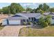 Attractive home showcasing a brick driveway, mature landscaping, and a freshly painted blue exterior at 206 Timberview Dr, Safety Harbor, FL 34695