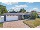 Beautiful one-story home with a well-maintained front yard, mature trees, and an inviting brick driveway at 206 Timberview Dr, Safety Harbor, FL 34695