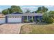 Charming one-story home featuring lush landscaping, beautiful curb appeal, and a brick-paved driveway at 206 Timberview Dr, Safety Harbor, FL 34695