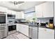 Kitchen with stainless appliances, white cabinets, and a breakfast bar with chairs at 206 Timberview Dr, Safety Harbor, FL 34695