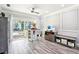 Bright living room area with gray walls, gray flooring, and access to the pool through sliding glass doors at 206 Timberview Dr, Safety Harbor, FL 34695