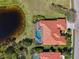 Aerial view of home with clay tile roof, screened lanai, and lake in backyard at 218 Pesaro Dr, North Venice, FL 34275
