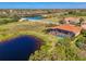 Aerial view of home with screened pool, tropical landscaping, and lake in gated community at 218 Pesaro Dr, North Venice, FL 34275
