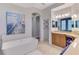 Elegant bathroom with a standalone tub, granite countertops, and ample cabinet space at 218 Pesaro Dr, North Venice, FL 34275