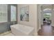 Bright bathroom featuring blue tile accents, a sailboat painting, and a modern, stand alone tub at 218 Pesaro Dr, North Venice, FL 34275