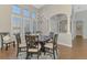 Dining area illuminated by a chandelier with natural light through windows and archway with pillars at 218 Pesaro Dr, North Venice, FL 34275