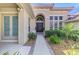 Elegant front entrance featuring a dark wood door, decorative plants, and manicured landscaping at 218 Pesaro Dr, North Venice, FL 34275