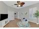 Bright living room featuring wood floors, ceiling fan, and plantation shutters at 218 Pesaro Dr, North Venice, FL 34275