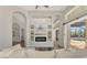 Cozy living room with a fireplace, arches, and glass doors leading to the outdoor pool area at 218 Pesaro Dr, North Venice, FL 34275