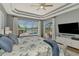 Bright main bedroom featuring tray ceiling, large windows, and scenic views of the pool and backyard at 218 Pesaro Dr, North Venice, FL 34275