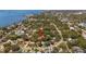 Wide aerial view showing the property's location within a leafy neighborhood near a body of water and city buildings at 219 Park S Cir, Dunedin, FL 34698