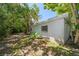 Spacious backyard setting with a set of lawn chairs beneath shady mature trees at 219 Park S Cir, Dunedin, FL 34698