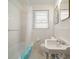 Bright bathroom featuring tiled walls, a shower-tub combo, and a classic sink at 219 Park S Cir, Dunedin, FL 34698