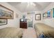 Shared bedroom with two twin beds, a dresser, and artwork on the walls at 219 Park S Cir, Dunedin, FL 34698