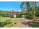 Charming single story house with a well-maintained lawn, lush trees and bougainvillea at 219 Park S Cir, Dunedin, FL 34698