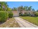 A cozy home featuring well-manicured landscaping and a stone driveway leading to the garage at 219 Park S Cir, Dunedin, FL 34698
