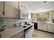 Classic kitchen featuring vintage appliances and cabinets, ample countertop space, and a window overlooking a treed lot at 219 Park S Cir, Dunedin, FL 34698