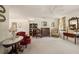 Light-filled living room with a ceiling fan, assorted antique furnishings, neutral carpet and a decorative folding screen at 219 Park S Cir, Dunedin, FL 34698