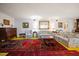 Spacious living room with floral sofas, decorative rugs, and traditional furnishings at 219 Park S Cir, Dunedin, FL 34698