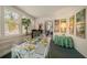 Bright and airy sunroom with white furniture, a glass-top table and large windows at 219 Park S Cir, Dunedin, FL 34698